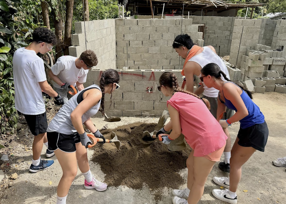Volunteers mixing cement on a LiveDifferent home build