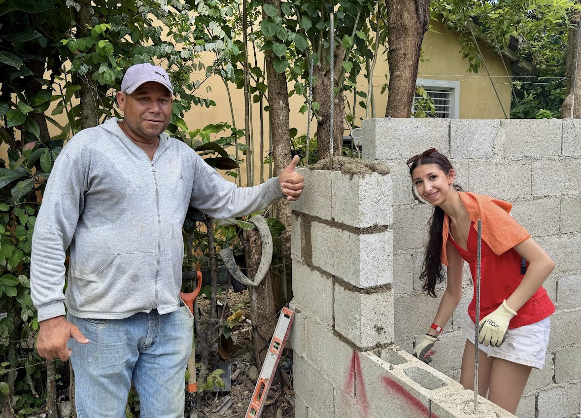 Build day, morning — volunteers laying cinder blocks for a family home